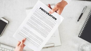 Sur Un Bureau, Une Main Donne à Une Autre Un Document De Procuration. Clavier, Stylo, Cahier, Portable