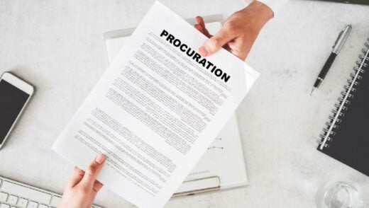 Sur Un Bureau, Une Main Donne à Une Autre Un Document De Procuration. Clavier, Stylo, Cahier, Portable