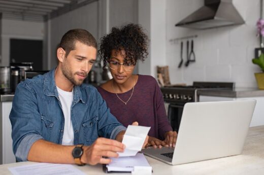 Homme Et Femme Qui Regardent Une Note Devant Un Ordinateur pour ouvrir un compte joint
