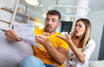 Homme Et Femme Sur Un Canapé Choqués Devant Un Document