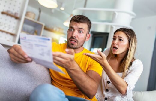 Homme Et Femme Sur Un Canapé Choqués Devant Un Document