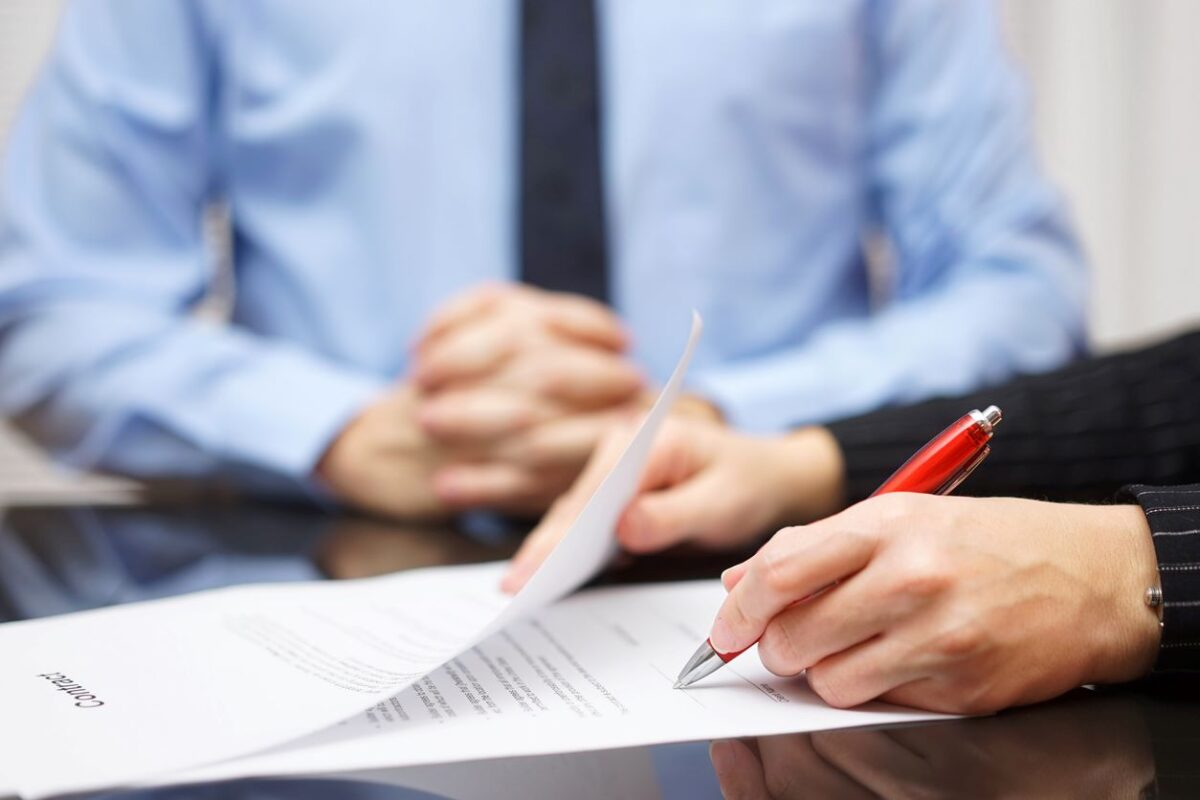 Femme Signature contrat avec homme d'affaires en arrière-plan