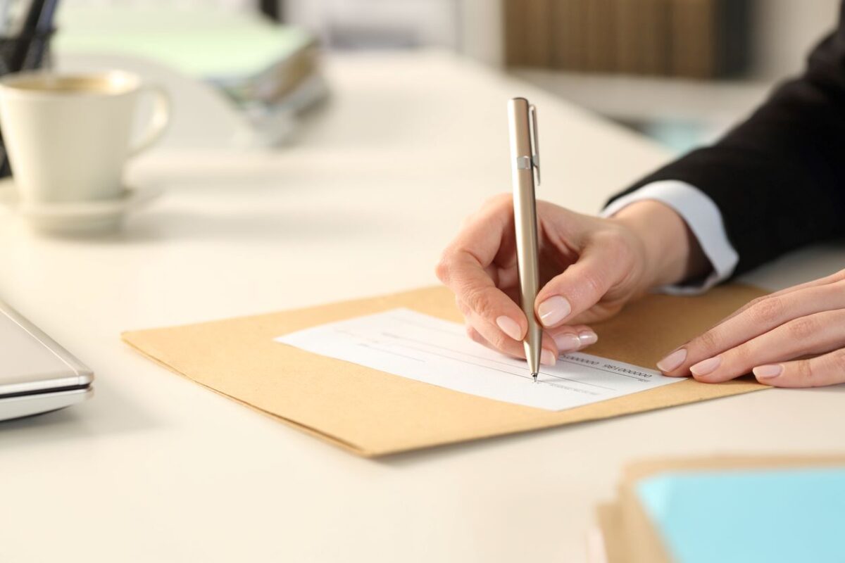 Main de femme d’affaires remplissant le chèque